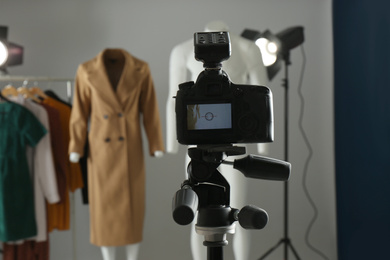 Ghost mannequins, clothes and professional lighting equipment in modern photo studio, focus on camera