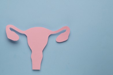 Photo of Woman`s health. Paper uterus on light blue background, top view with space for text