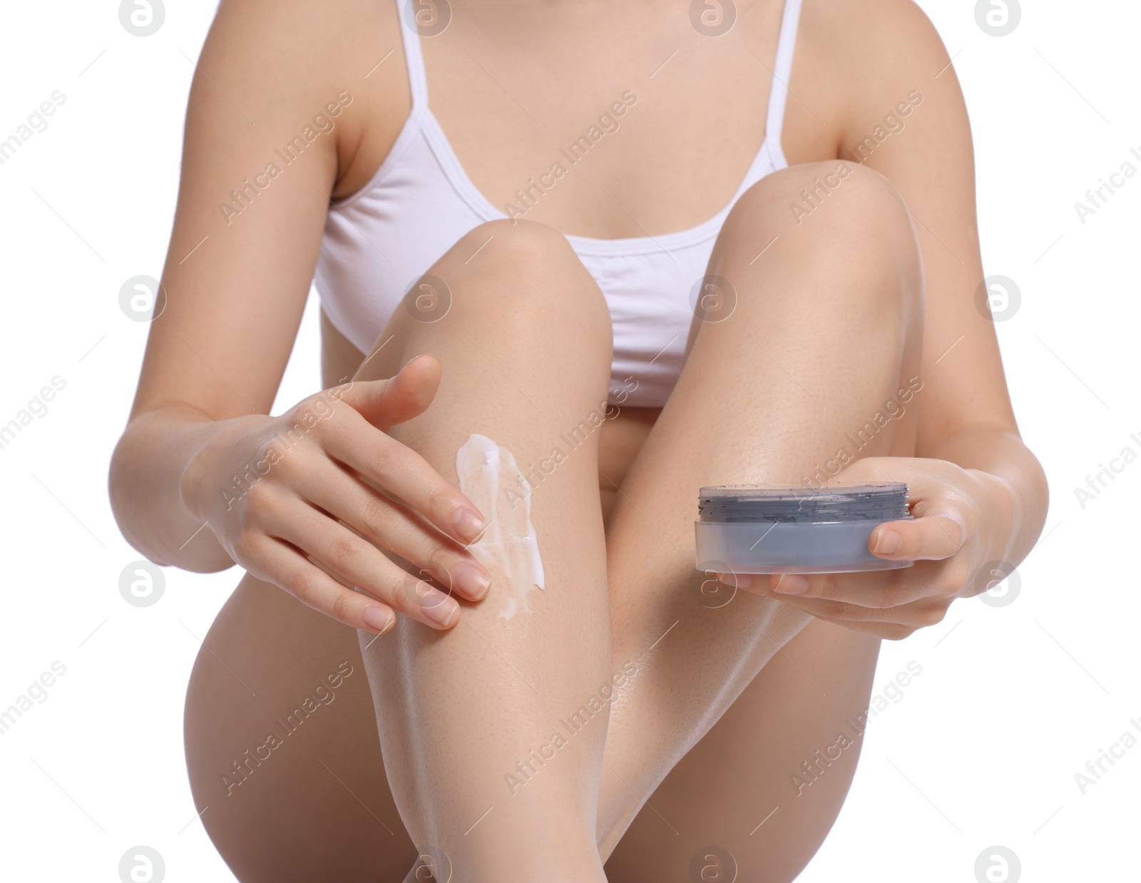 Photo of Woman applying body cream onto legs on white background, closeup