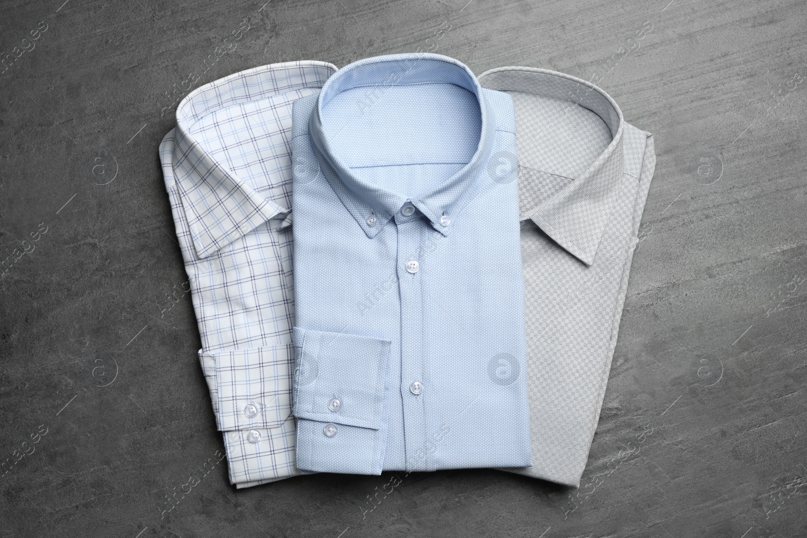 Photo of Stylish male shirts on grey background, flat lay