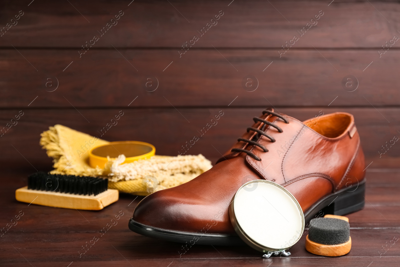 Photo of Shoe care products and footwear on wooden table. Space for text