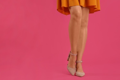 Photo of Woman wearing stylish shoes on pink background, closeup. Space for text