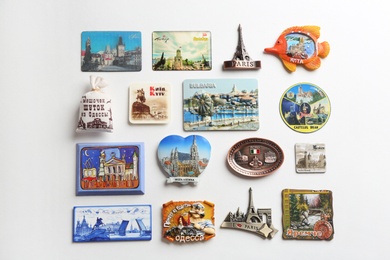 Photo of MYKOLAIV, UKRAINE - DECEMBER 25, 2018: Many different souvenir magnets on white background, flat lay