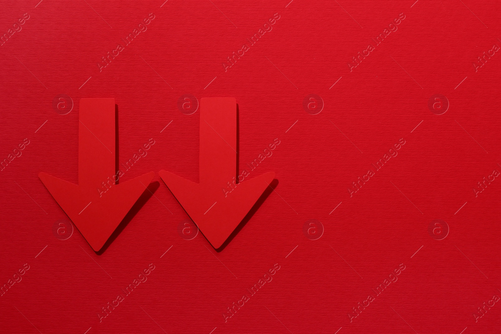 Photo of Paper arrows on red background, flat lay. Space for text