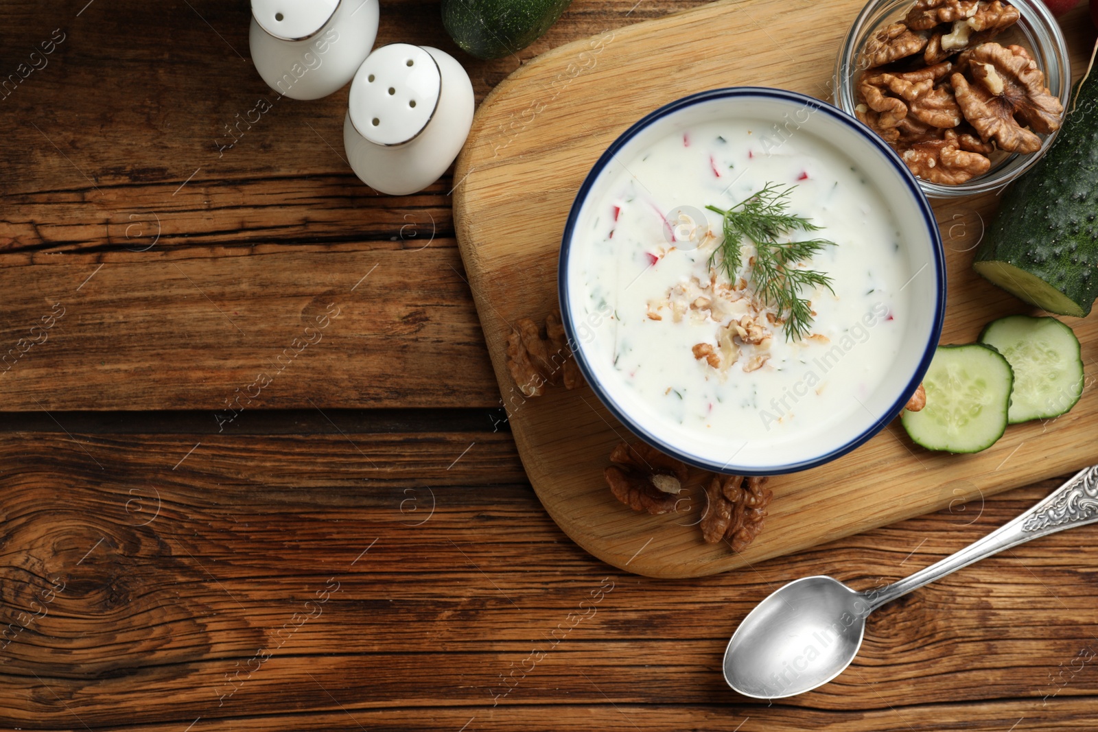 Photo of Delicious cold summer soup on wooden table, flat lay. Space for text