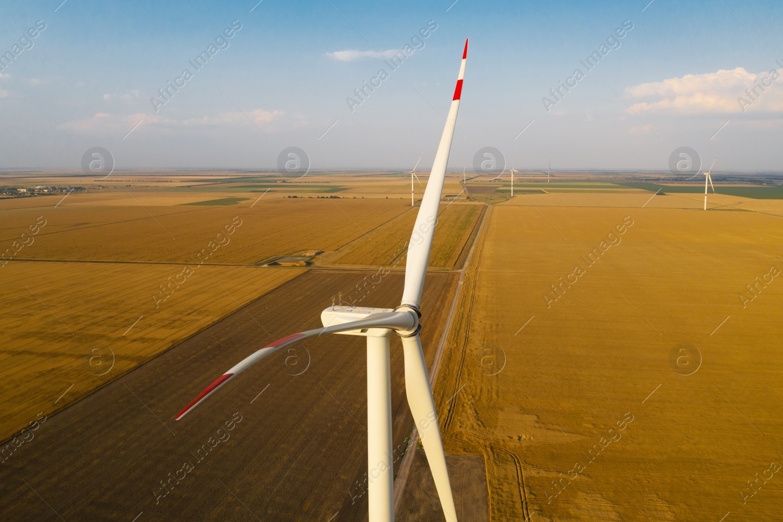 Image of Modern wind turbine under blue sky. Alternative energy source