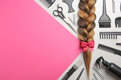 Flat lay composition with braid, hairdresser's tools and space for text on color background