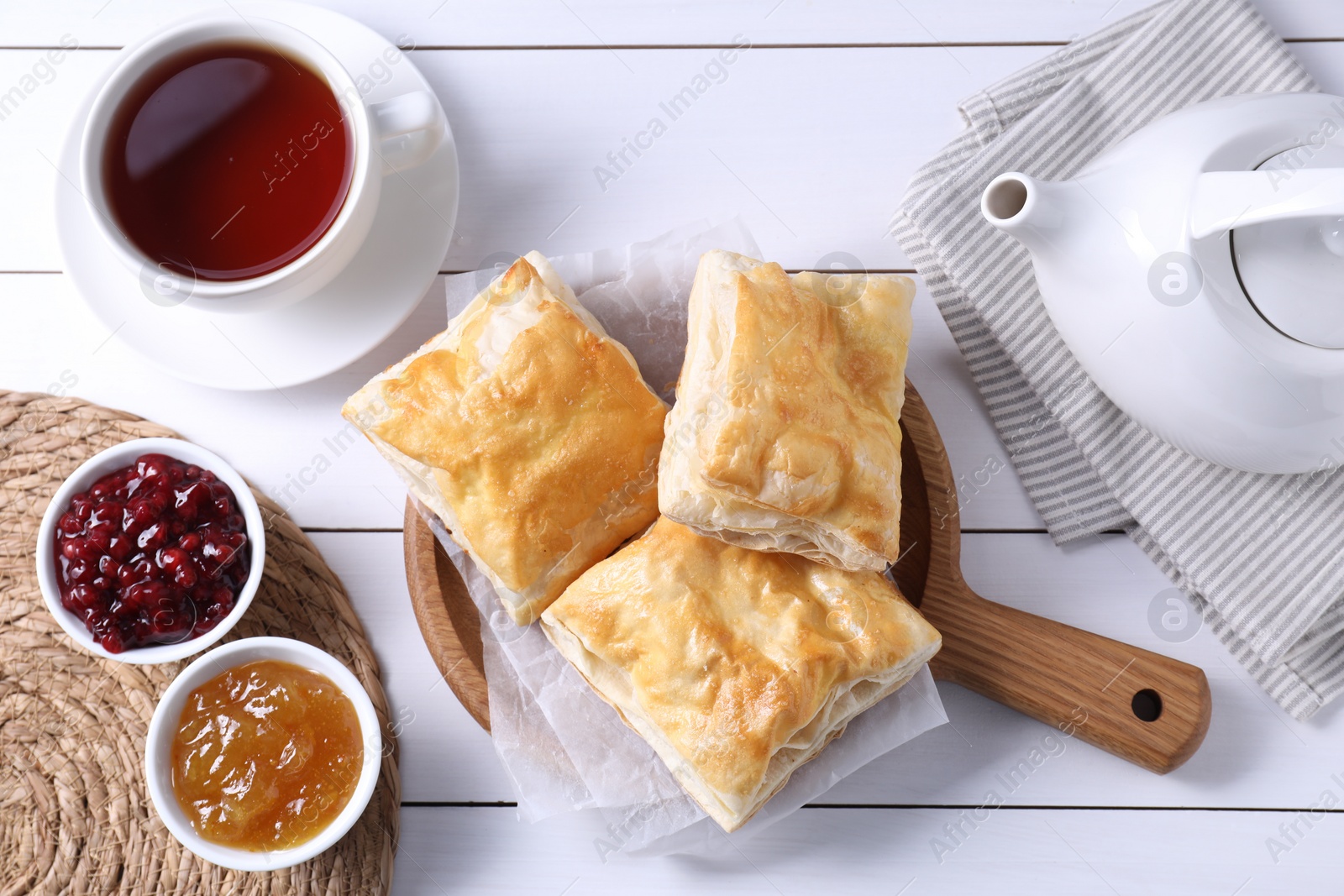 Photo of Delicious puff pastry served on white wooden table, flat lay