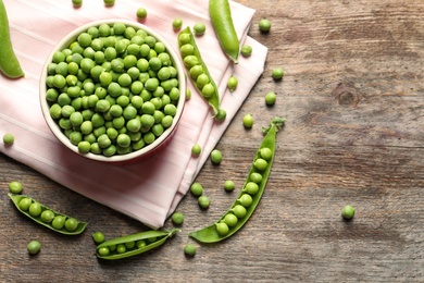 Photo of Flat lay composition with green peas on wooden background