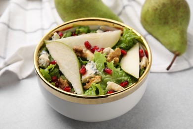 Photo of Delicious pear salad in bowl on light table, closeup