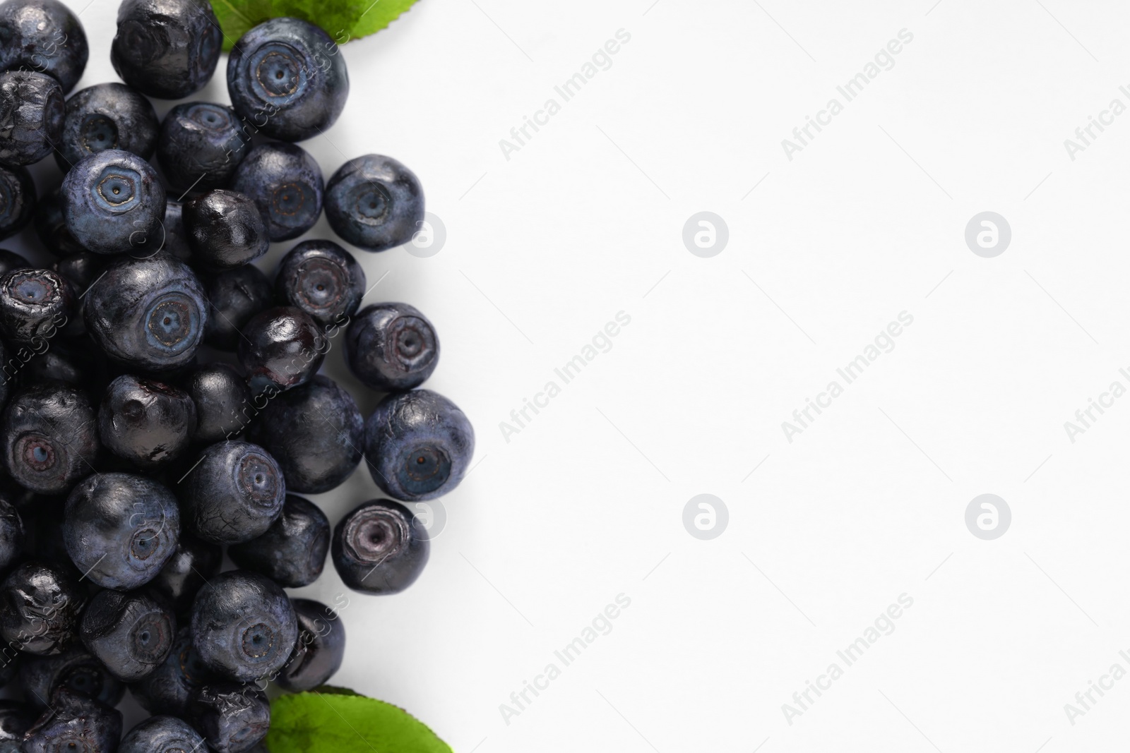 Photo of Pile of ripe bilberries on white background, flat lay. Space for text