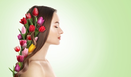 Image of Pretty woman wearing beautiful wreath made of flowers on light green background, space for text