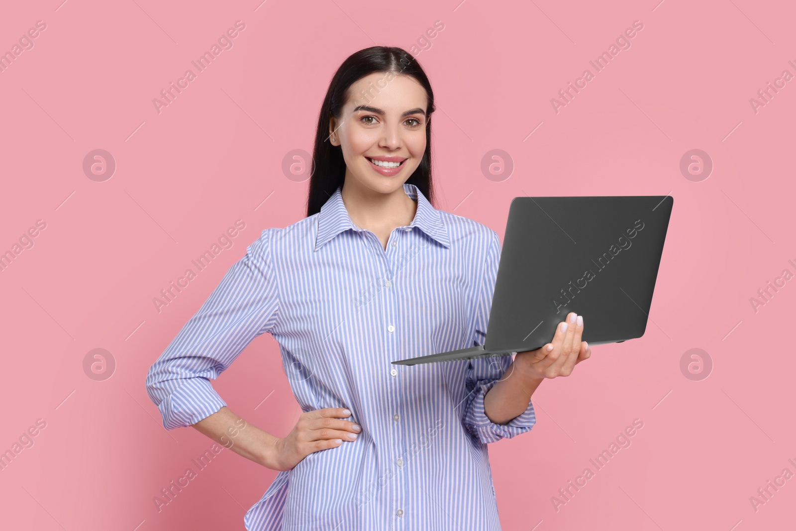 Photo of Happy woman with laptop on pink background