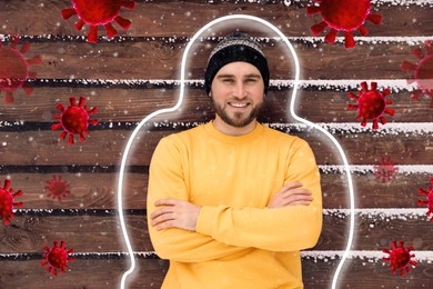 Man with strong immunity surrounded by viruses near wooden wall outdoors in winter