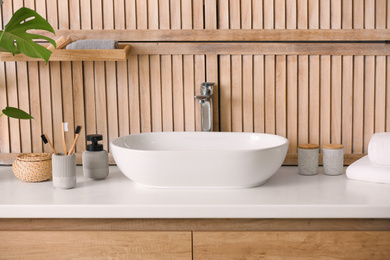 Stylish vessel sink near wooden wall in modern bathroom