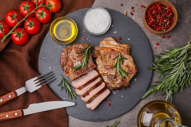 Photo of Pieces of delicious fried meat with rosemary served on brown table, flat lay