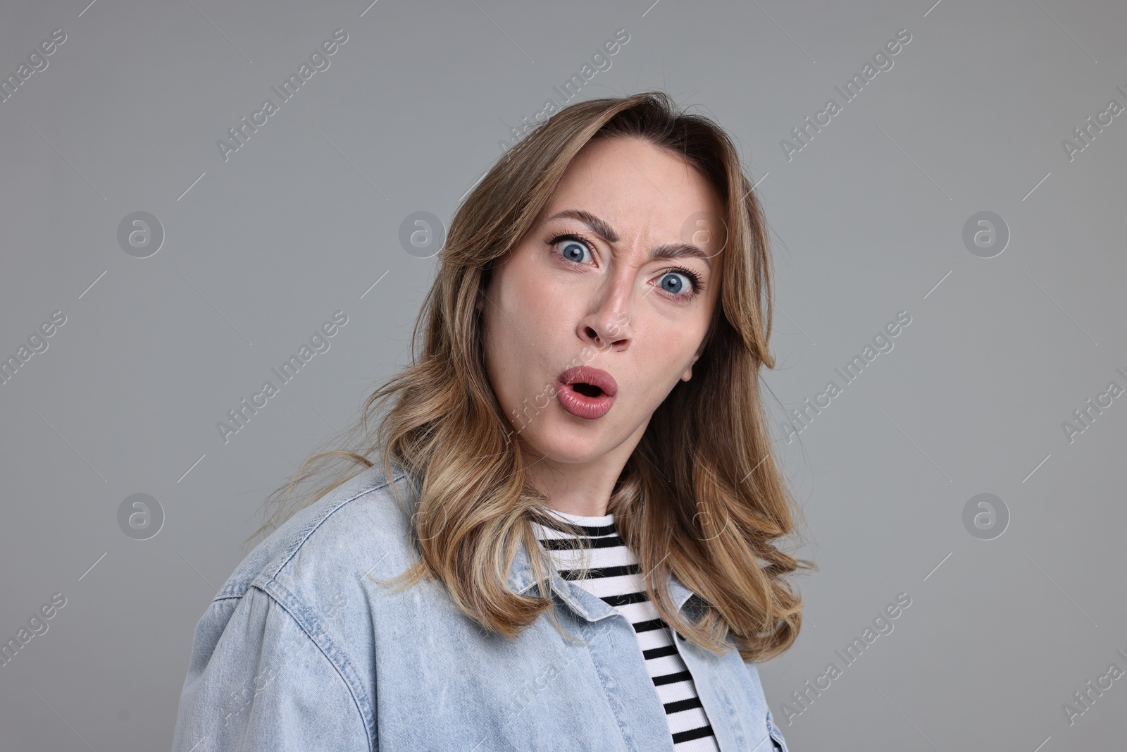 Photo of Portrait of surprised woman on grey background