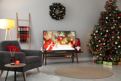 Photo of Stylish living room interior with modern TV and Christmas tree