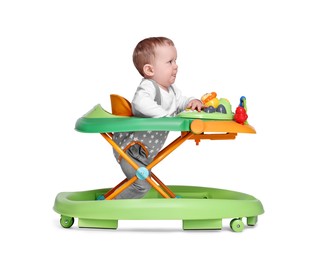Cute little boy making first steps with baby walker on white background