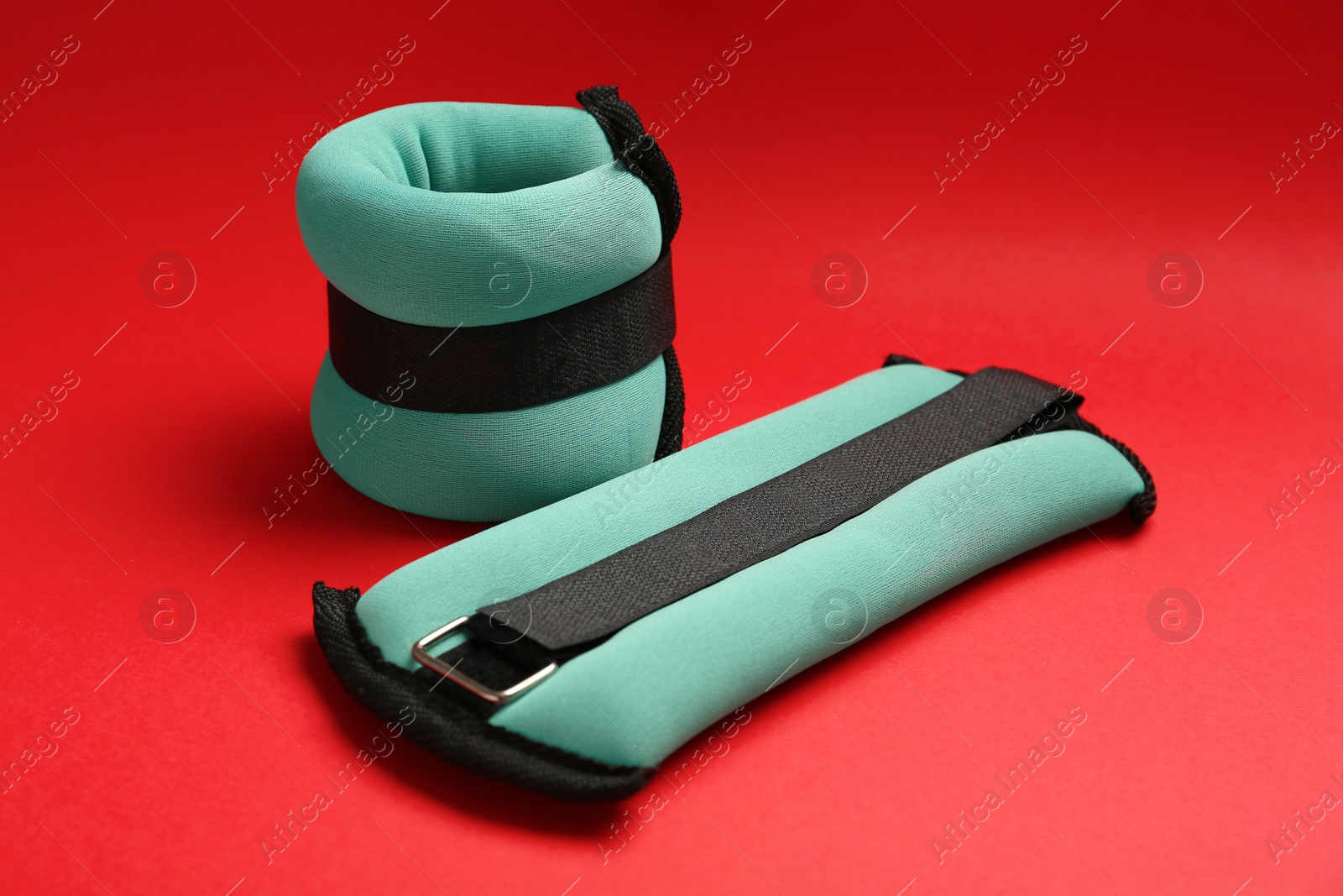 Photo of Stylish turquoise weighting agents on red background