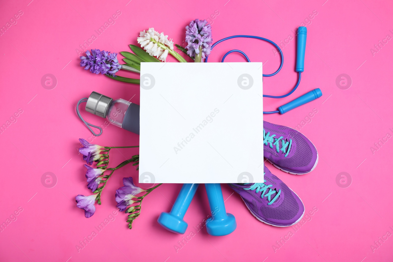 Photo of Flat lay composition with spring flowers, sports items and blank card on pink background. Space for text