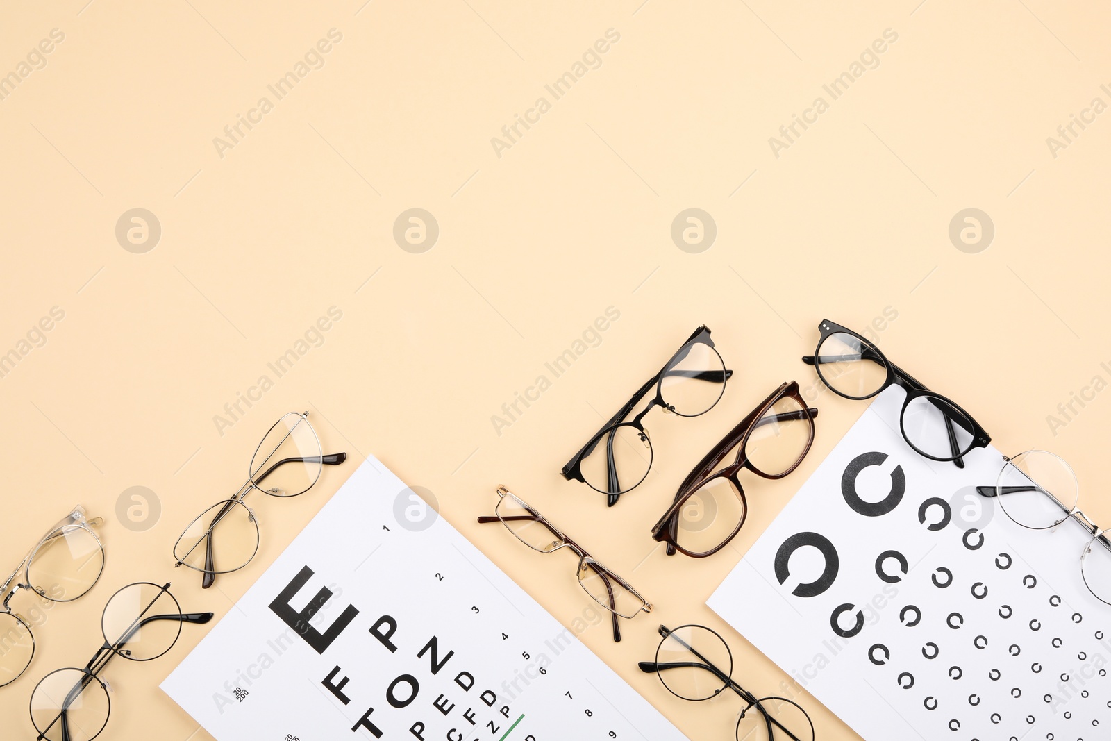 Photo of Vision test chart and glasses on beige background, flat lay. Space for text