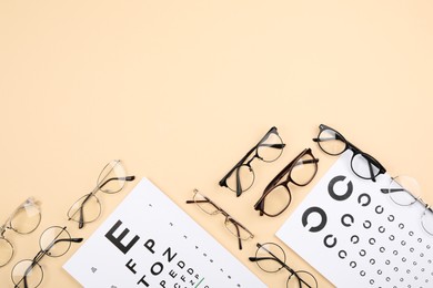 Vision test chart and glasses on beige background, flat lay. Space for text