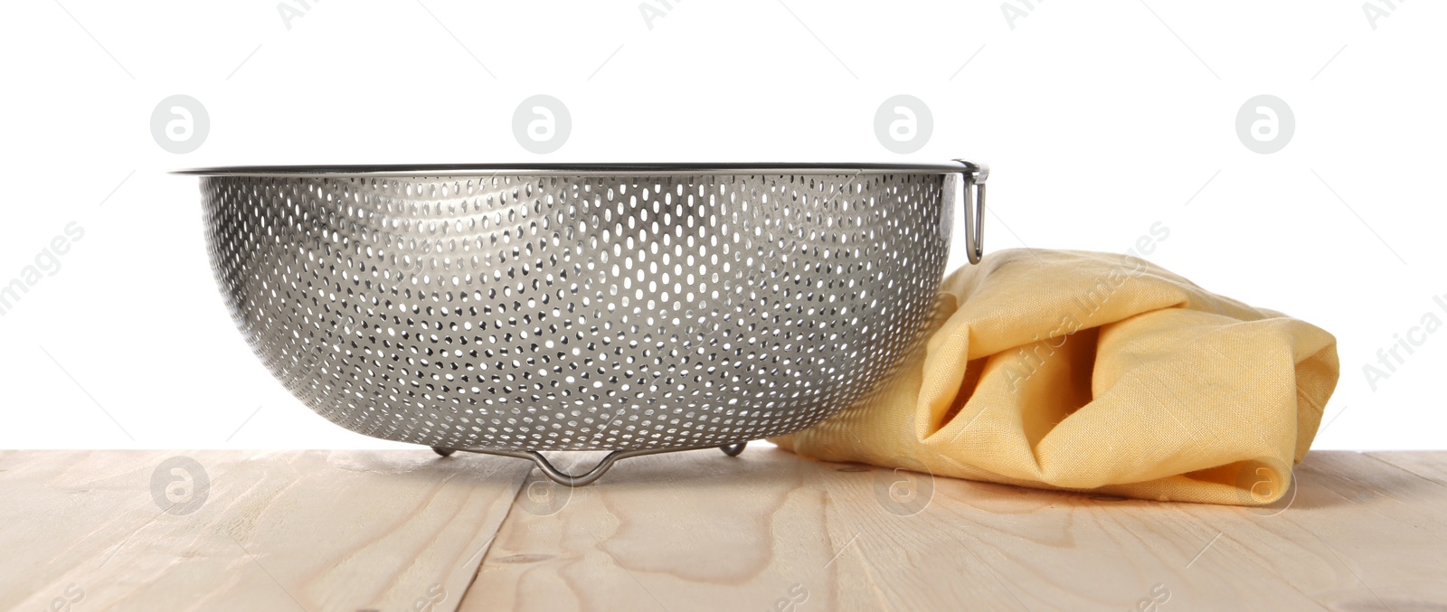 Photo of Metal colander and napkin on wooden table against white background