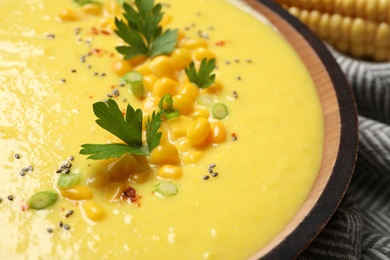 Delicious creamy corn soup in wooden bowl, closeup