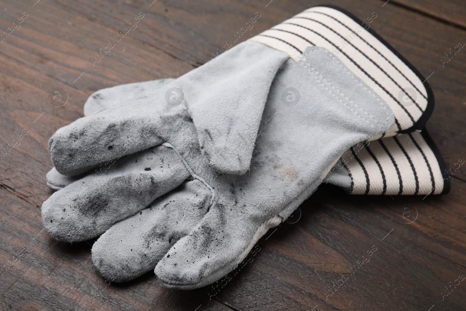 Photo of Pair of color gardening gloves on wooden table, closeup