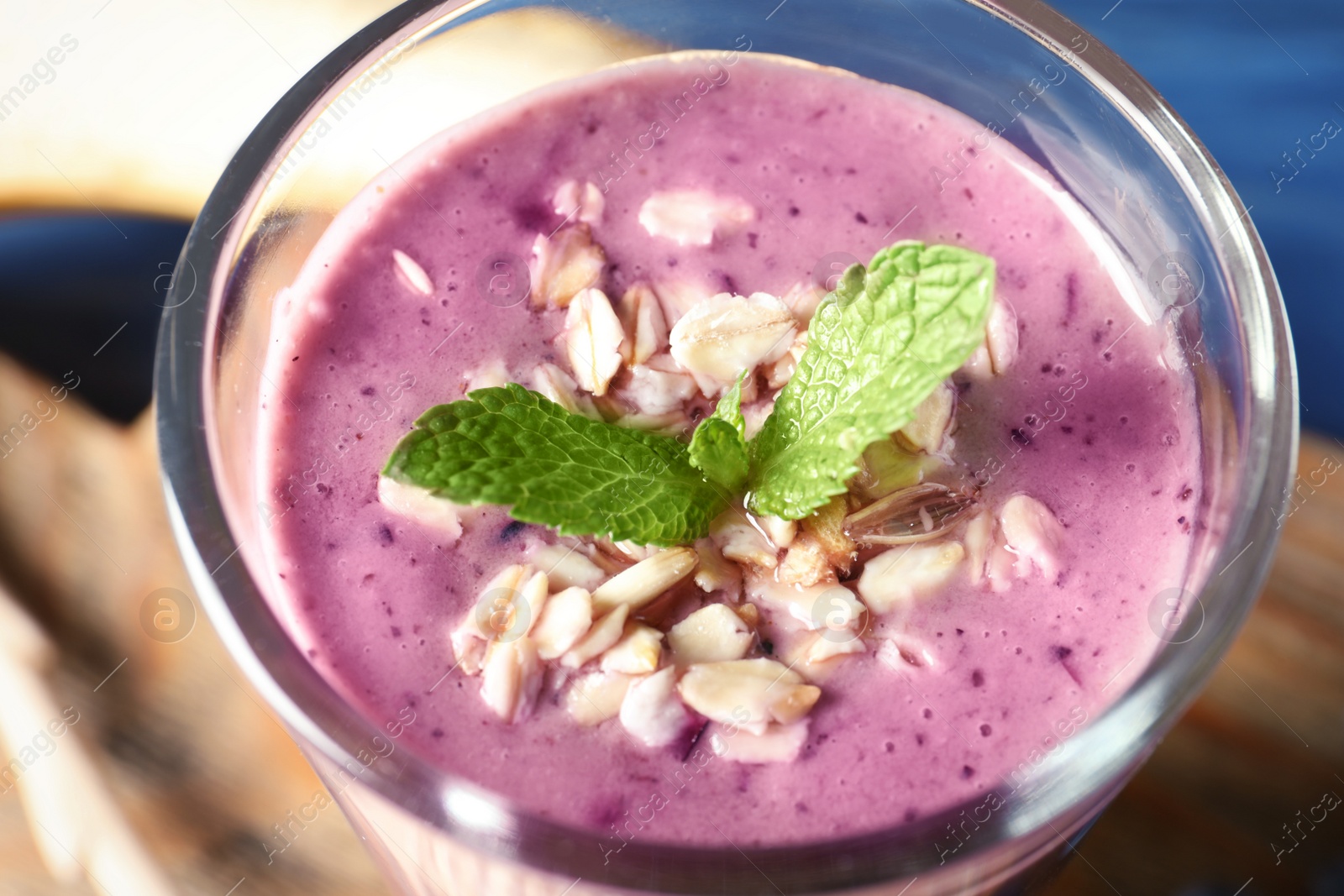 Photo of Glass of blueberry smoothie with oatmeal, closeup