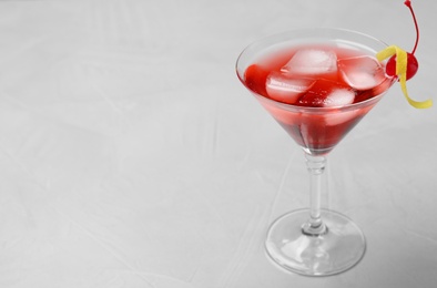 Glass of tasty refreshing cocktail on grey background, space for text