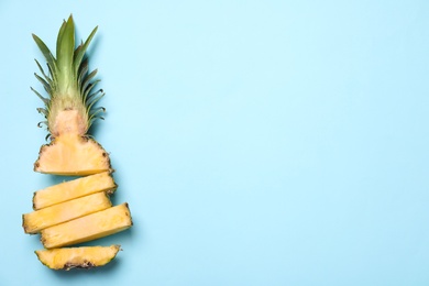 Photo of Cut fresh pineapple on light blue background, top view. Space for text