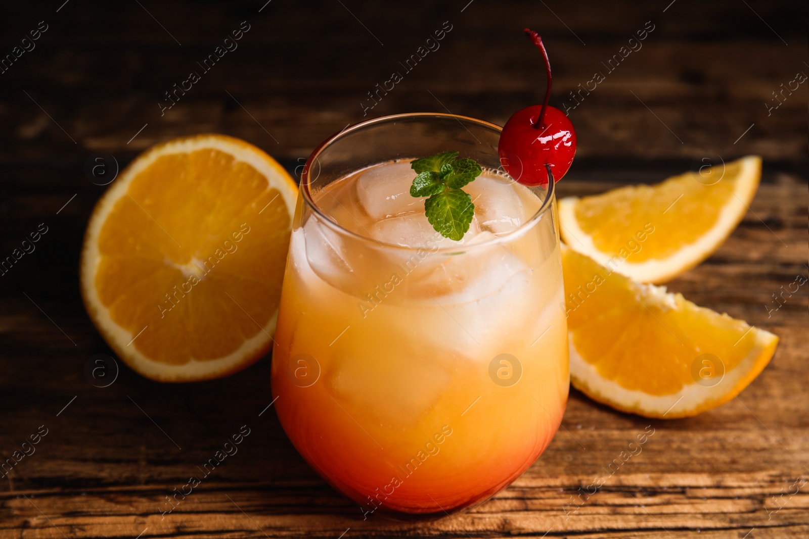 Photo of Fresh alcoholic Tequila Sunrise cocktail on wooden table