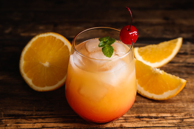 Photo of Fresh alcoholic Tequila Sunrise cocktail on wooden table