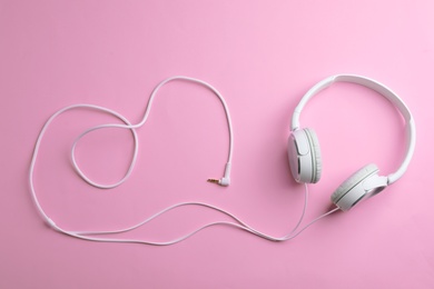 Photo of Stylish headphones on color background, top view