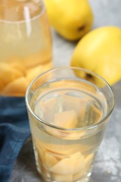 Delicious quince drink and fresh fruits on grey table, closeup