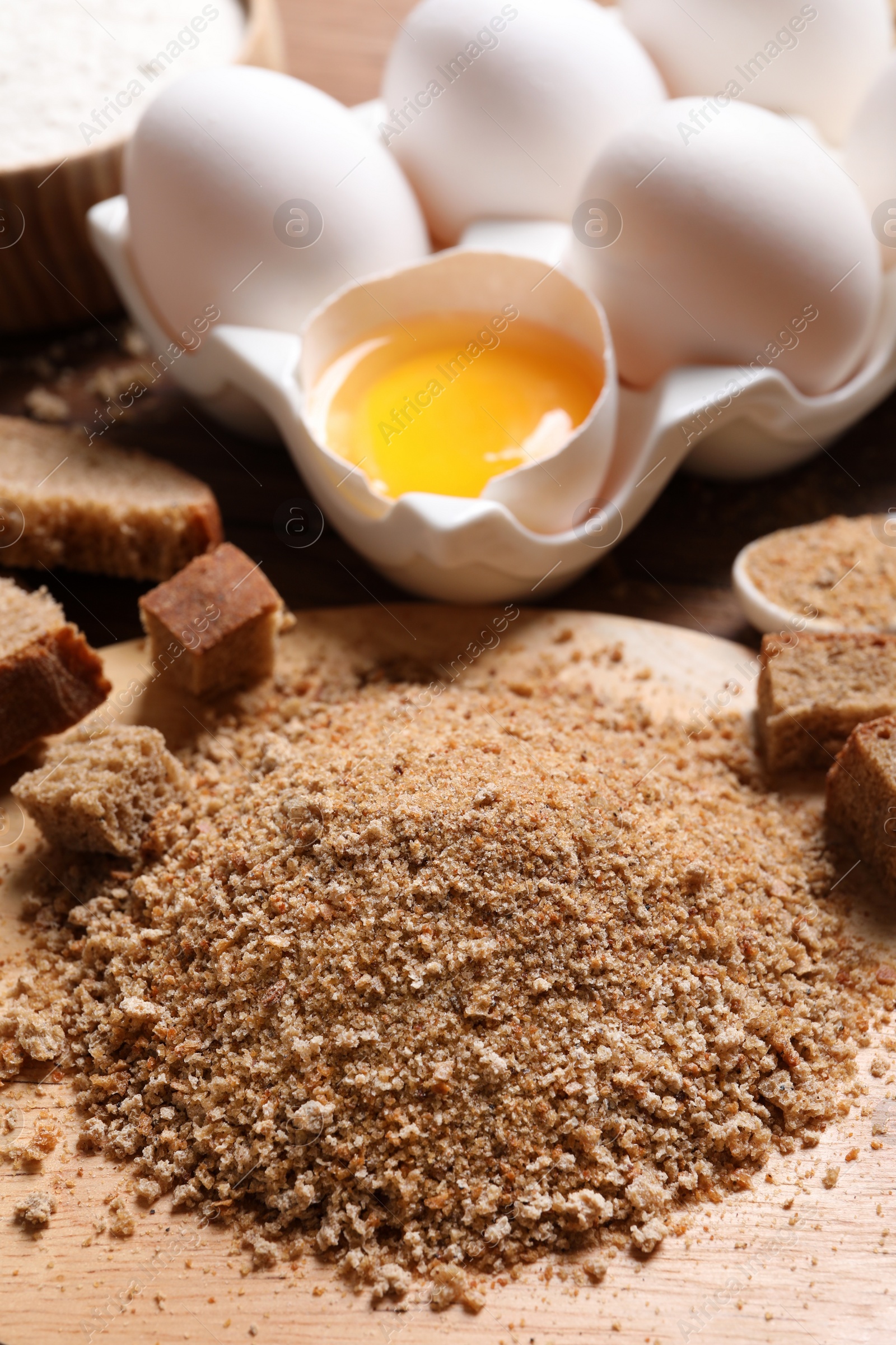 Photo of Fresh breadcrumbs and eggs on wooden table