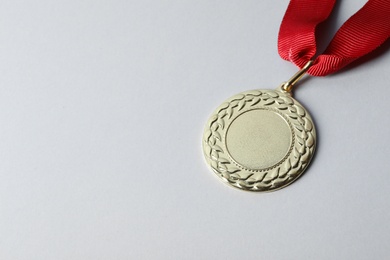 Photo of Gold medal with space for design on light background. Victory concept