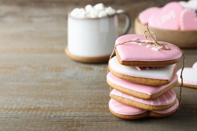 Stack of Valentine's day cookies on wooden table, closeup. Space for text