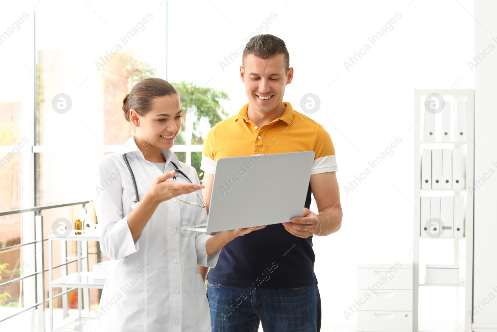 Photo of Young doctor consulting patient in modern hospital