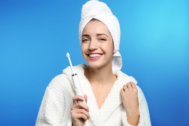 Photo of Portrait of young woman with electric toothbrush on color background