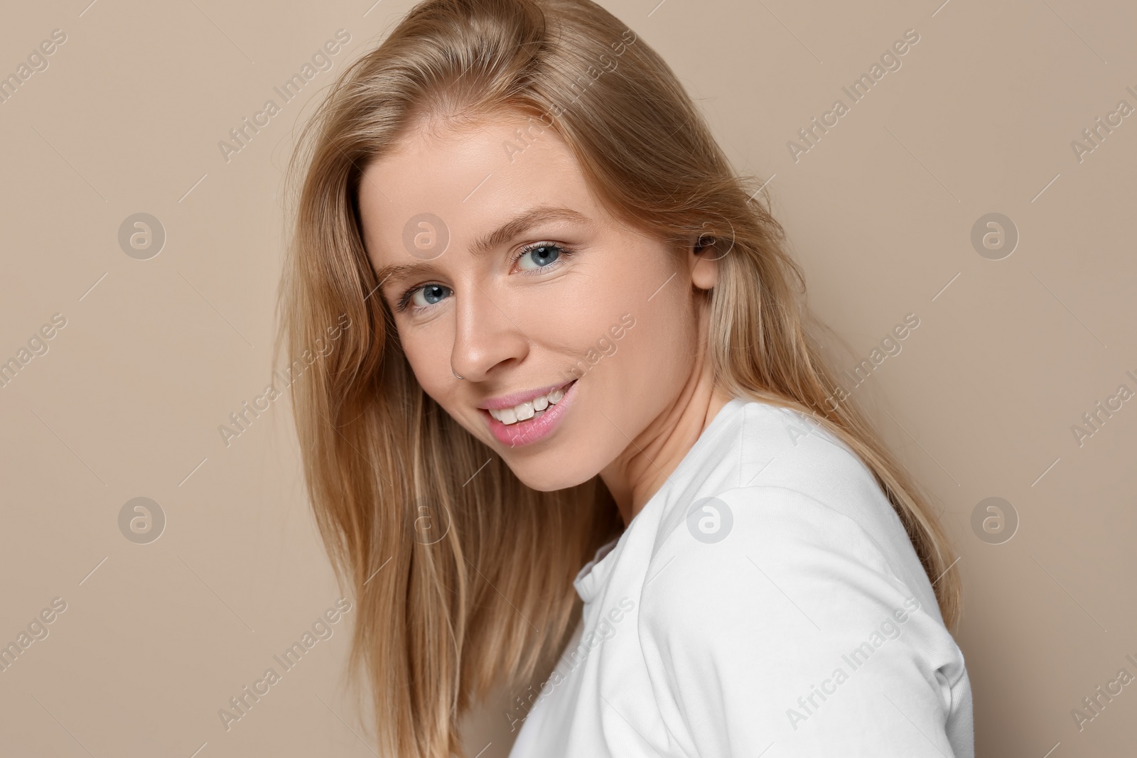 Photo of Portrait of beautiful young woman on beige background