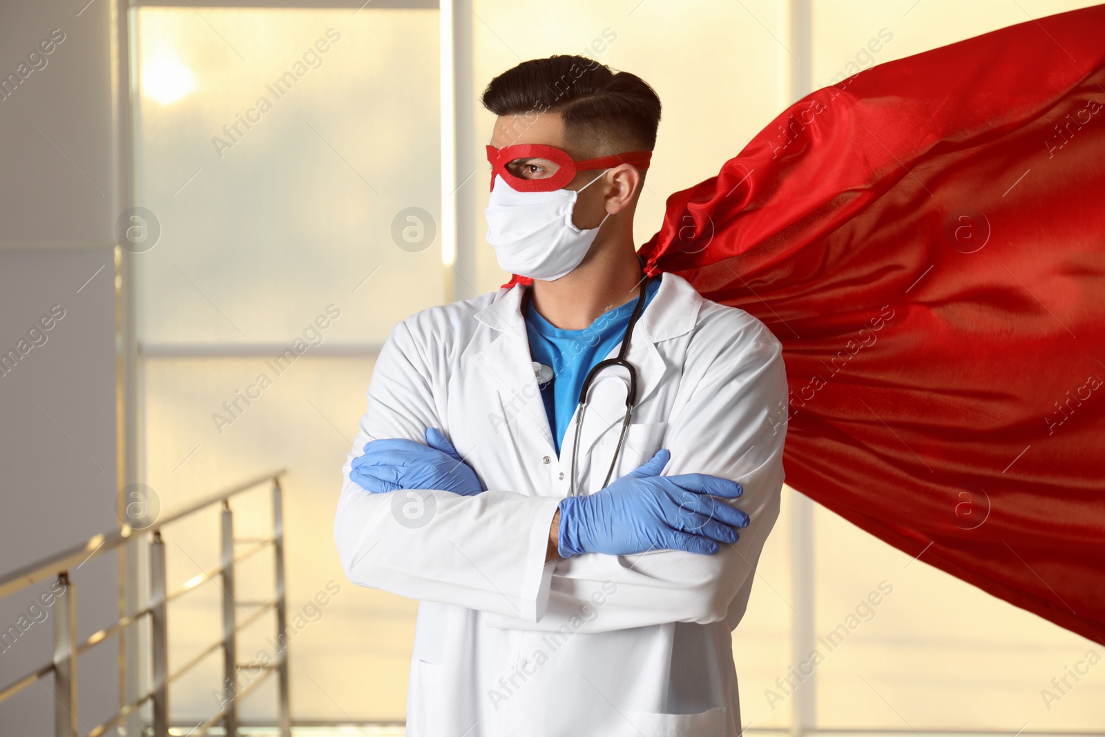 Photo of Doctor wearing face mask and cape indoors. Super hero power for medicine