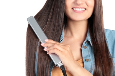 Young woman using hair iron on white background, closeup