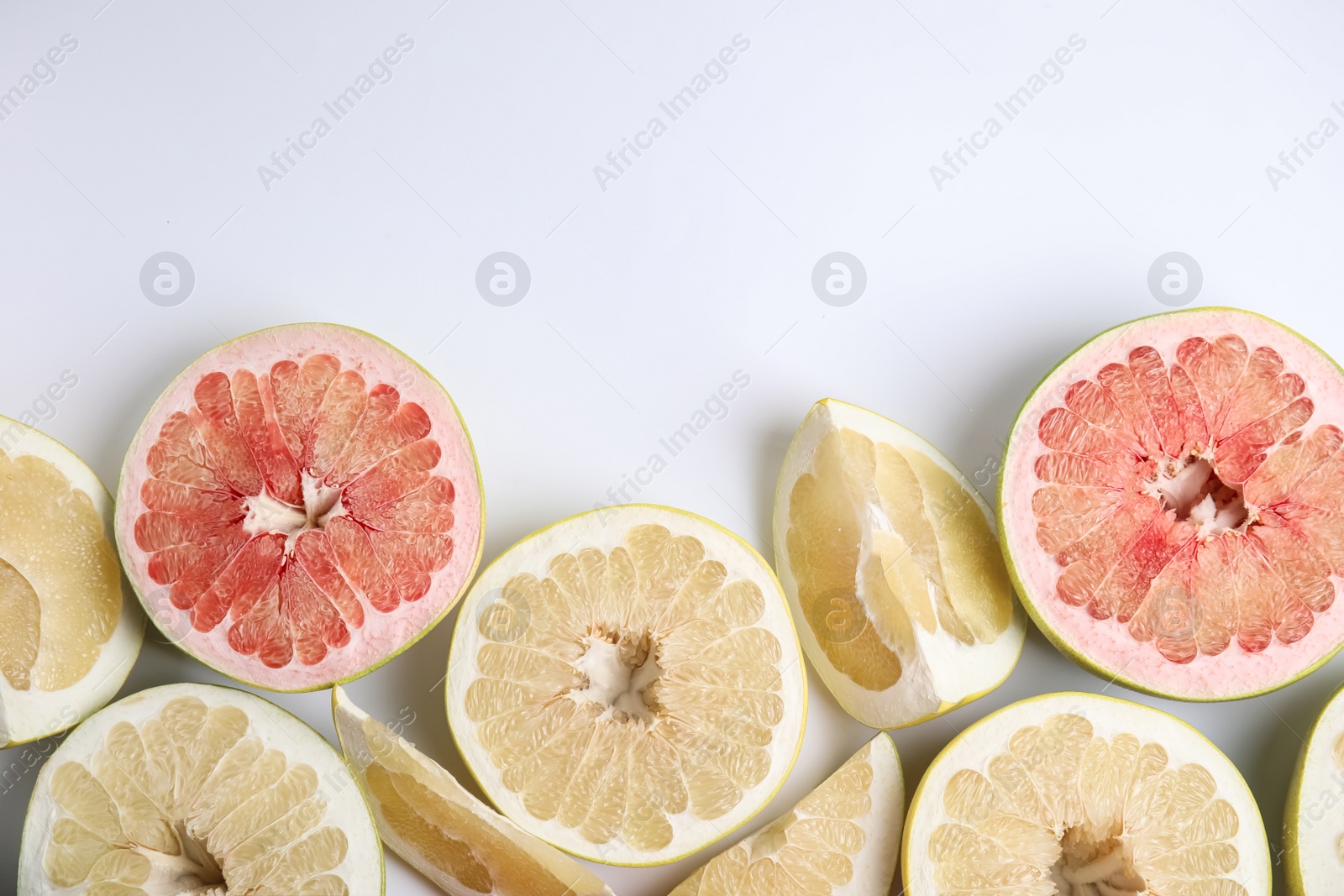 Photo of Fresh cut pomelo fruits on white background, top view