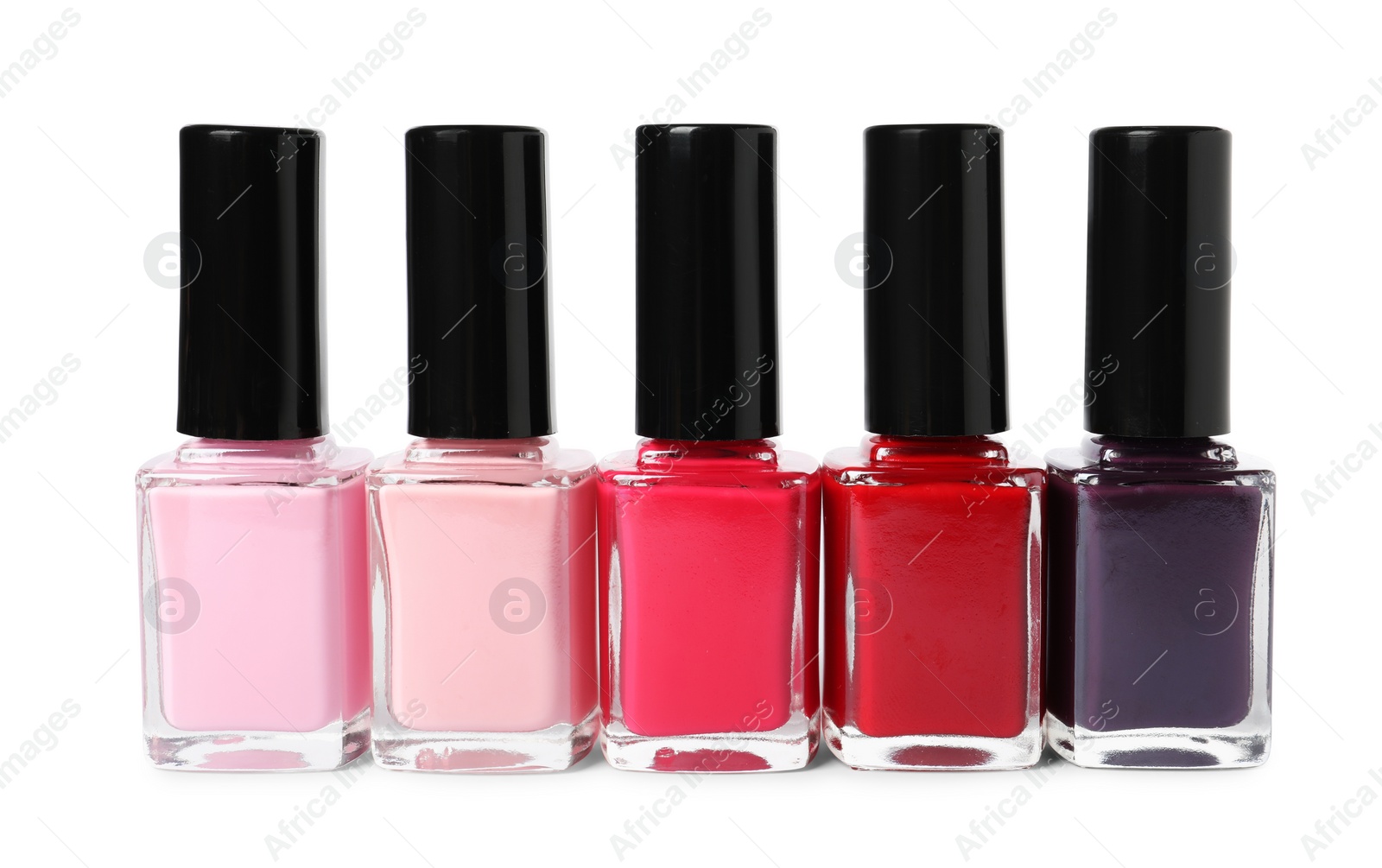 Photo of Bright nail polishes in bottles isolated on white