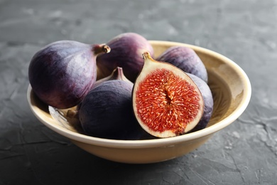 Photo of Bowl with fresh ripe figs on dark background. Tropical fruit