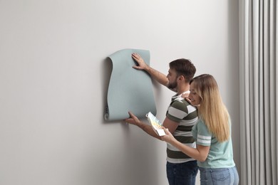Photo of Young couple with new wall paper and color palette  indoors