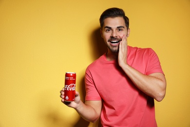 MYKOLAIV, UKRAINE - NOVEMBER 28, 2018: Young man with Coca-Cola can on color background, space for text